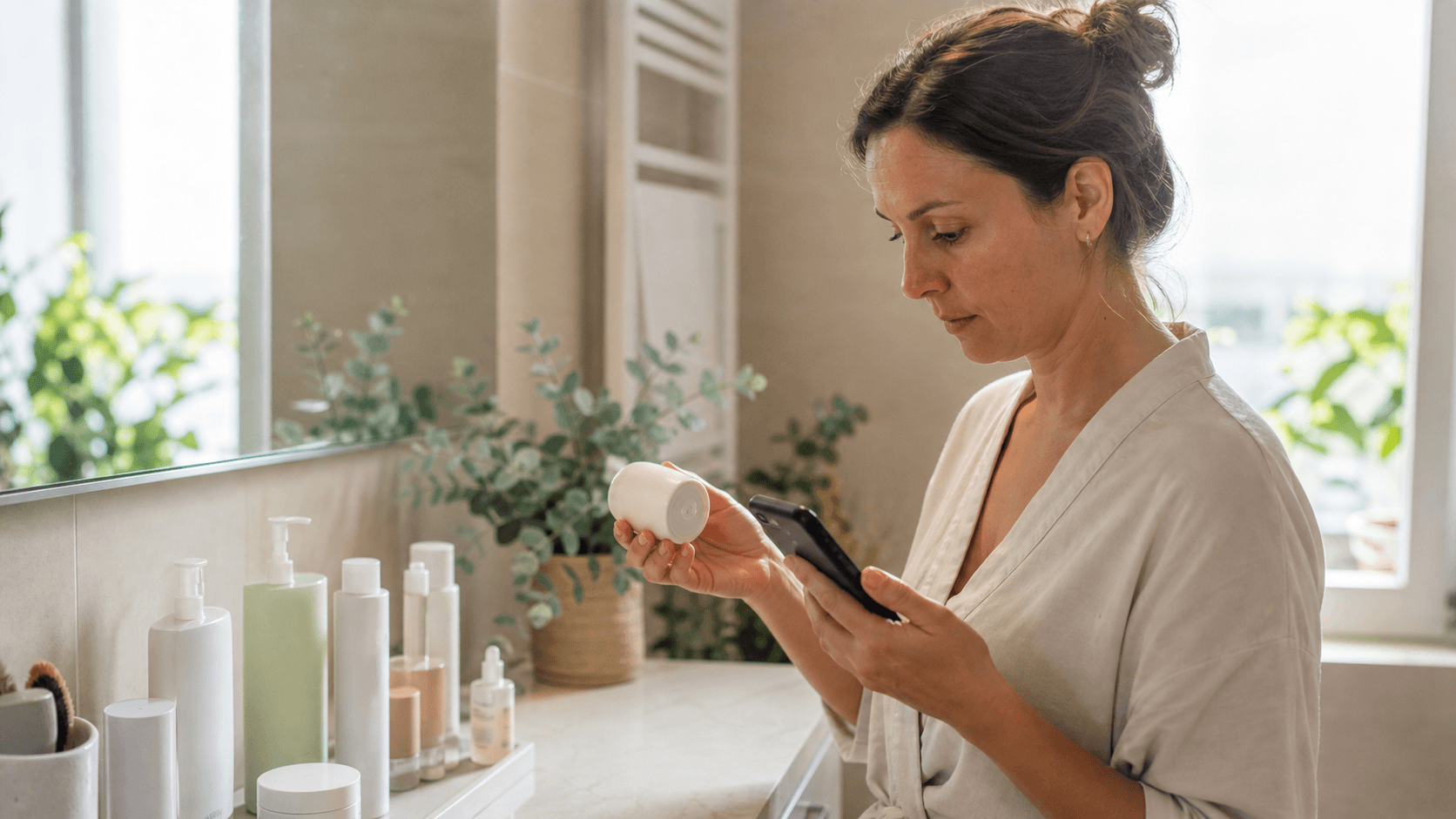 Femeie care verifică baza unui recipient cosmetic și consultă o alertă de siguranță pe telefon