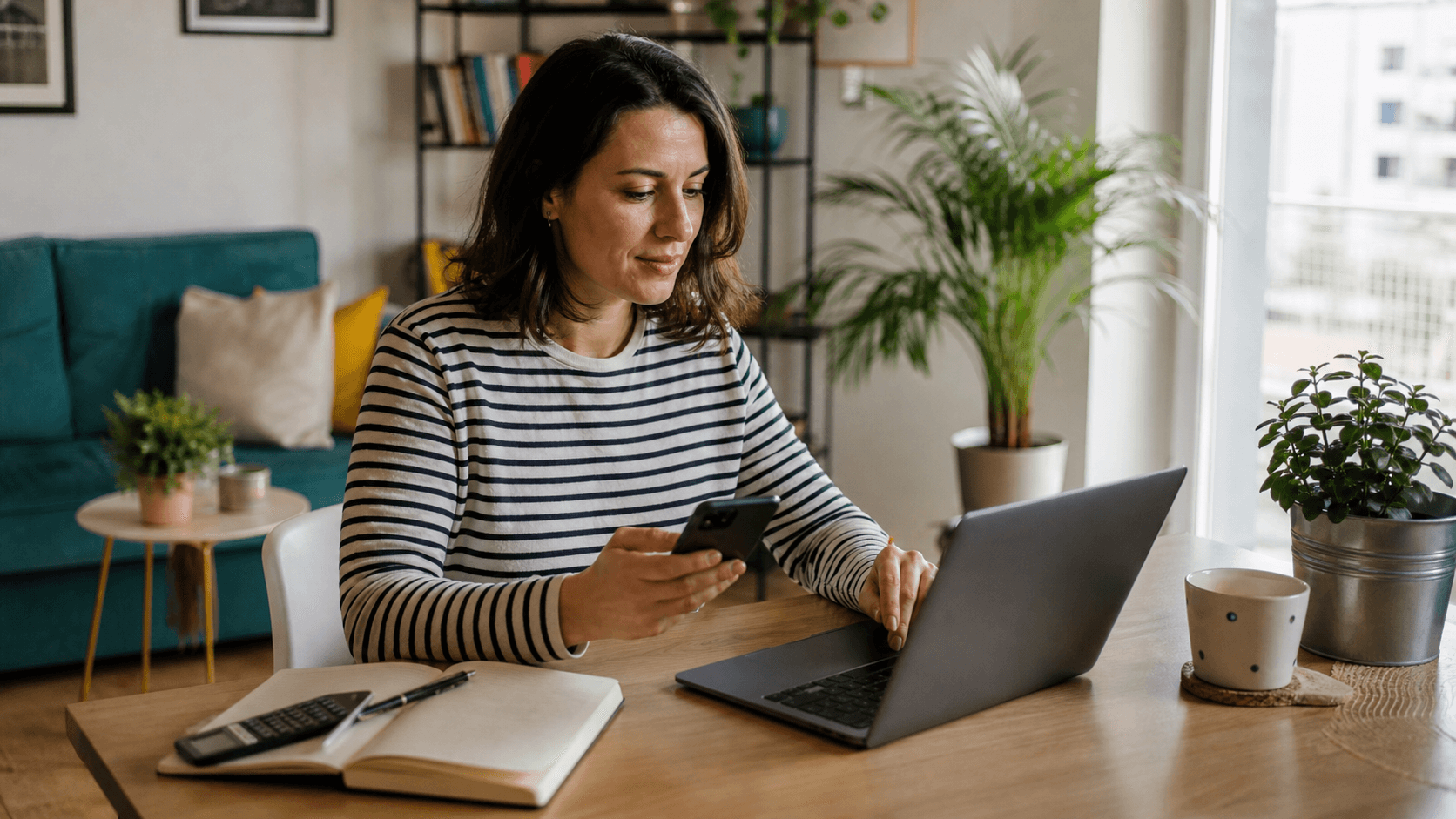 O femeie își verifică abonamentele digitale pe laptop și telefon